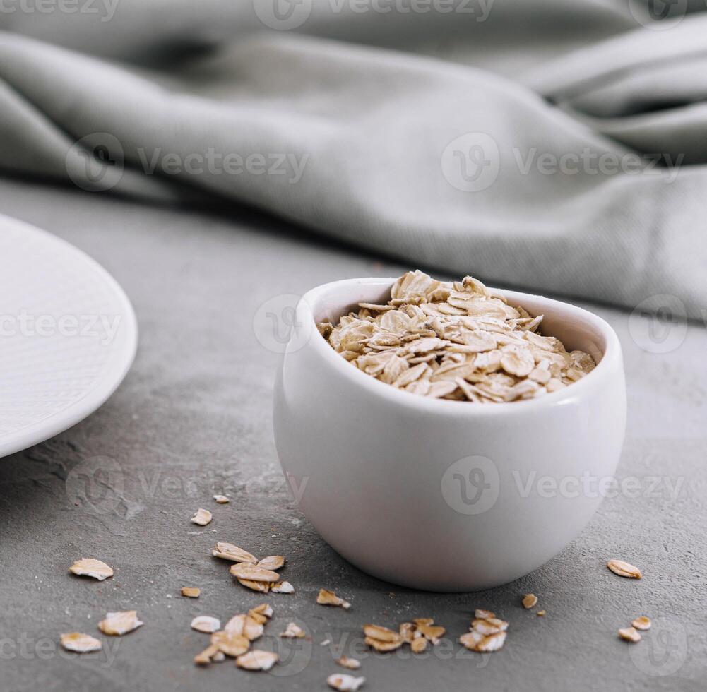 Dry rolled oat flakes oatmeal on bowl photo