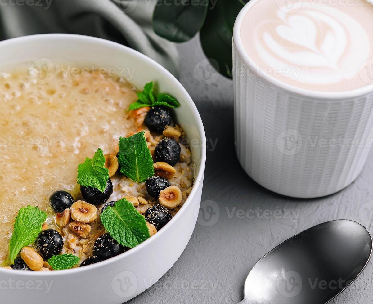 Oatmeal porridge with hazelnuts and blueberries in bowl photo