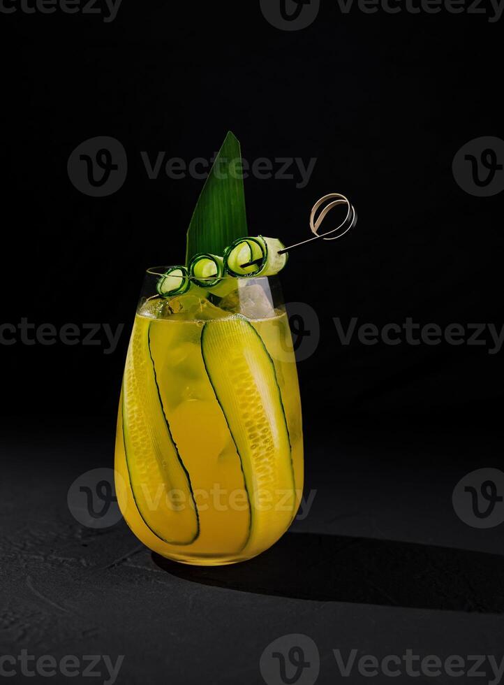 Refreshing cucumber cocktail on dark background photo