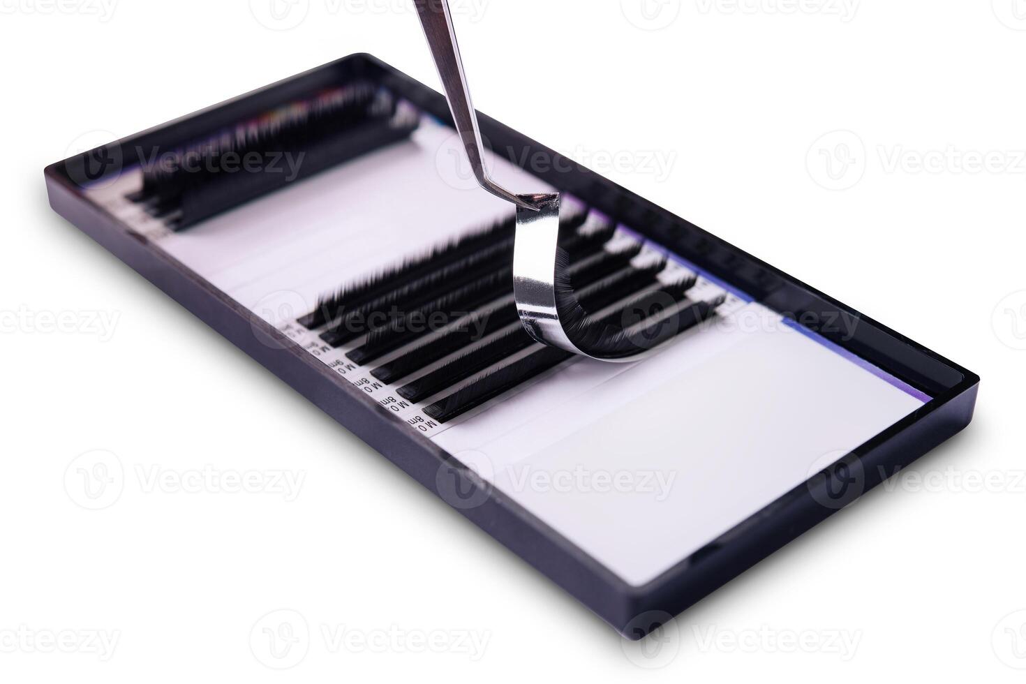Close-up image of tweezers holding an eyelash extension above a tray photo