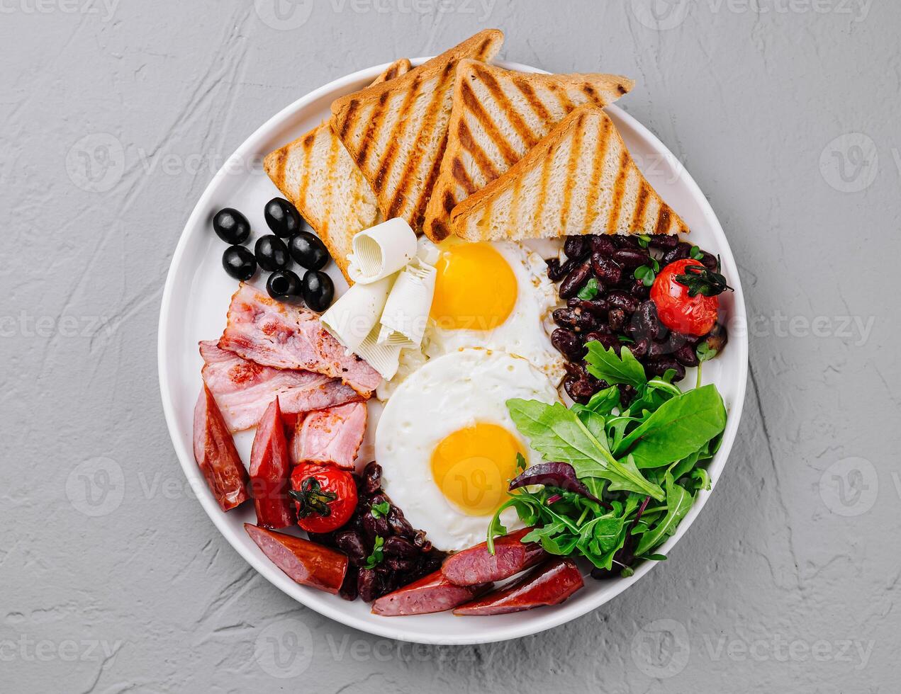 Full breakfast plate with eggs, bacon, and toast photo