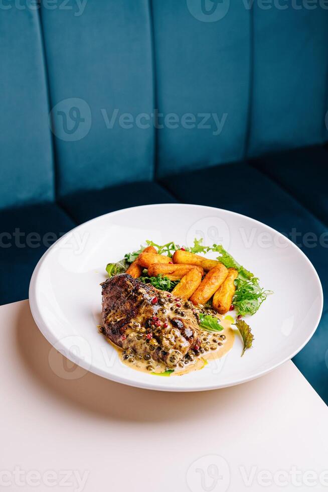 Gourmet steak with peppercorn sauce and fries photo