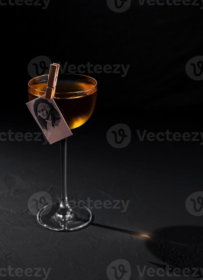 Elegant cocktail with photo garnish on dark background