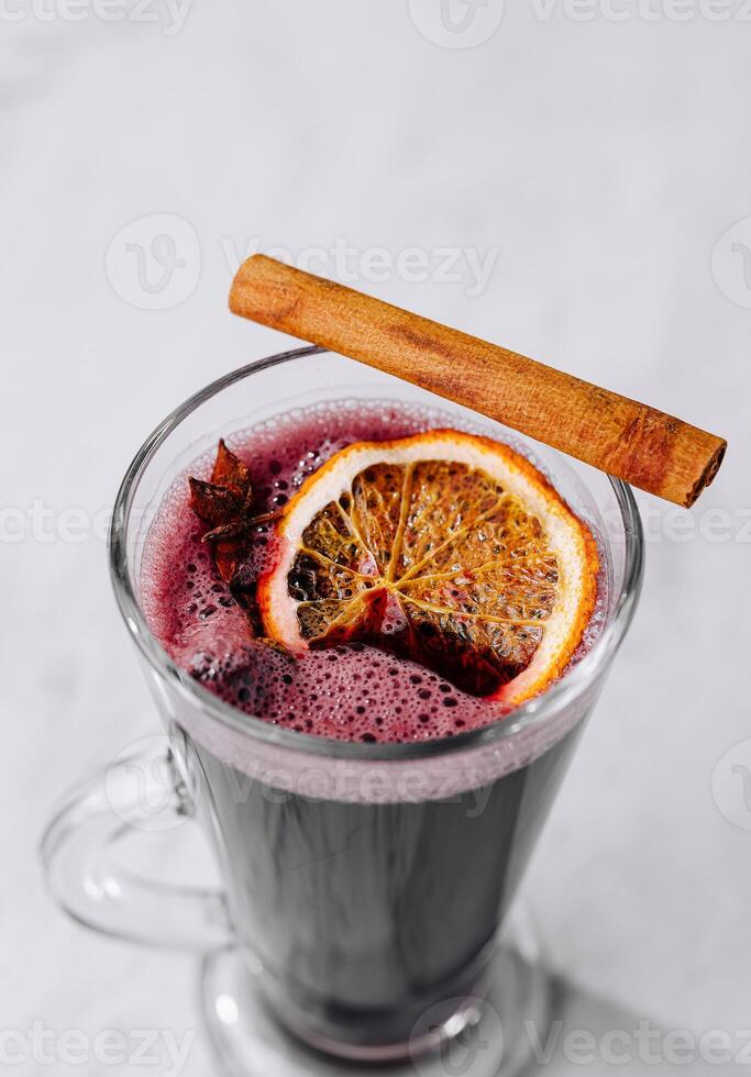 Mulled wine in glass with citrus and cinnamon photo