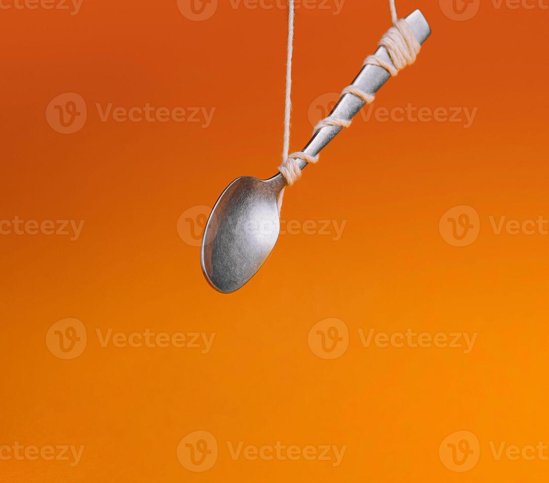 Levitating spoon on orange background photo