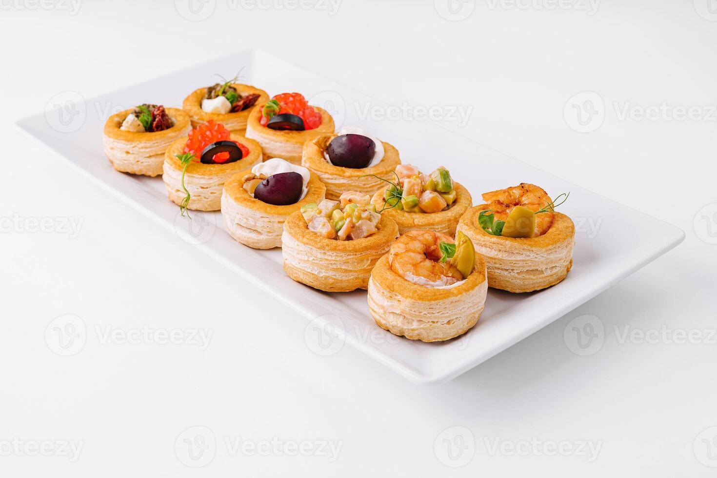 Gourmet assorted mini tartlets on white plate photo