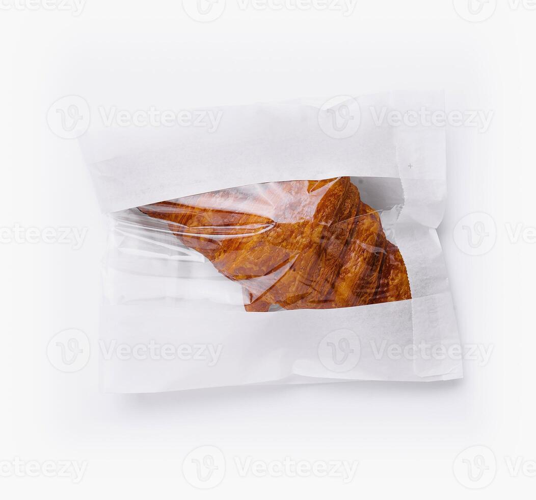 Sealed bag of loose croissant isolated on white photo