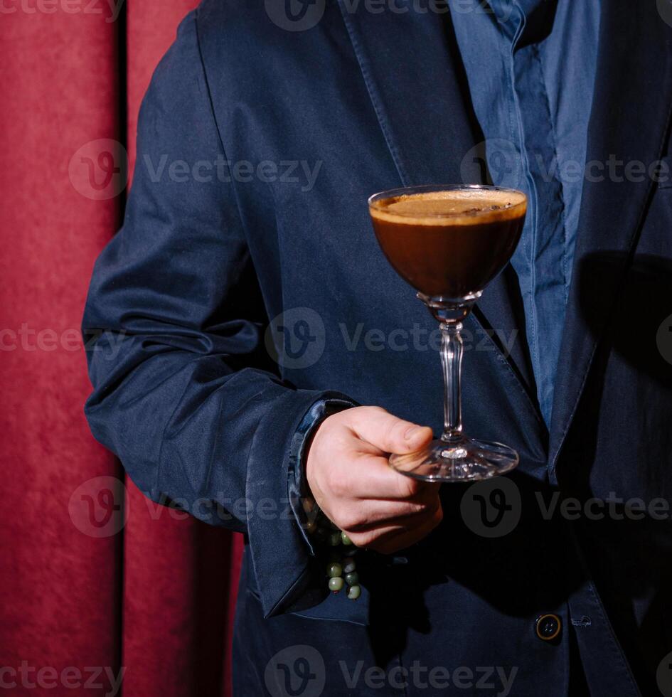 Man in suit holding espresso martini cocktail photo