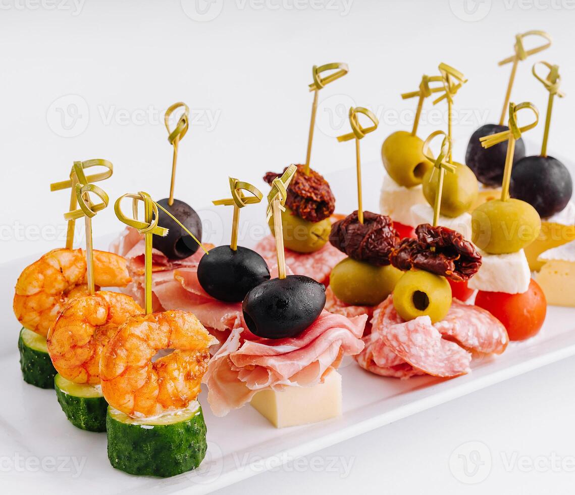Gourmet appetizer selection on a white platter against a clean backdrop photo