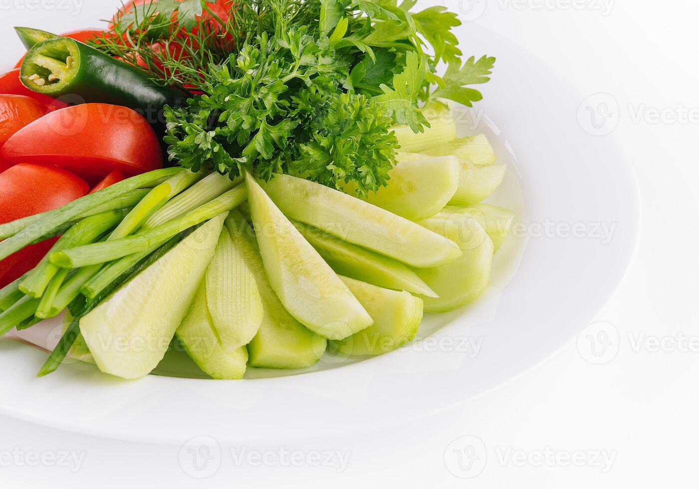 Vegan plate of fresh sliced cucumbers, green onions and cherry tomatoes photo