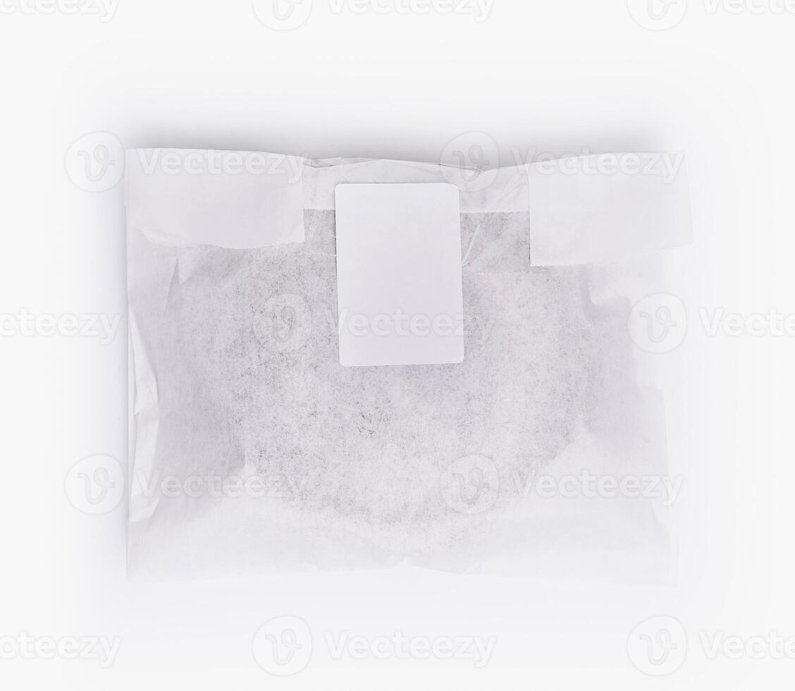 Sealed paper bag with blank label on white background photo