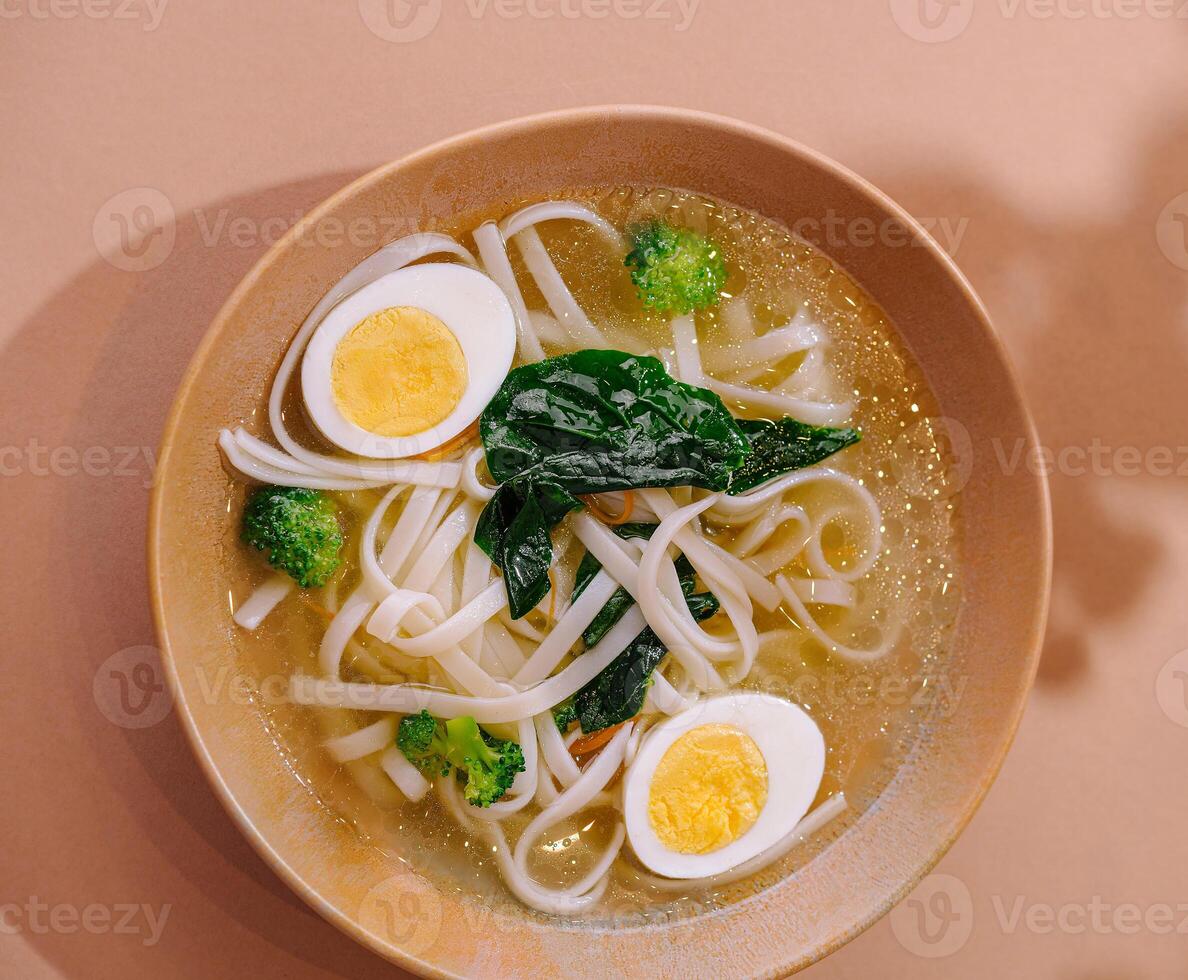 Delicious homemade udon noodle soup with egg and vegetables photo