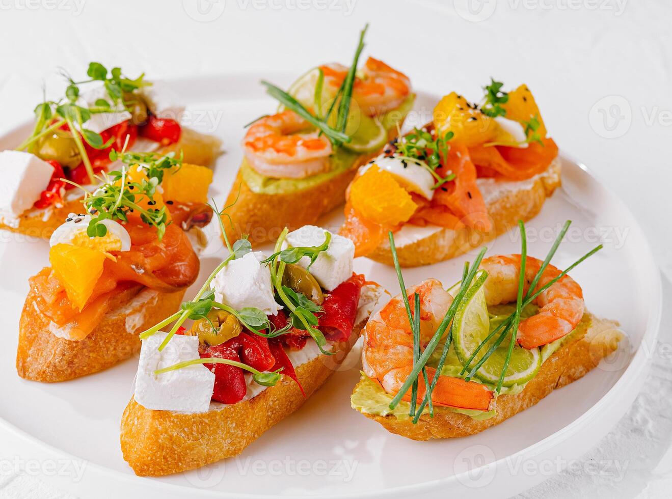 Elegant platter of assorted bruschetta with fresh toppings on a white background photo