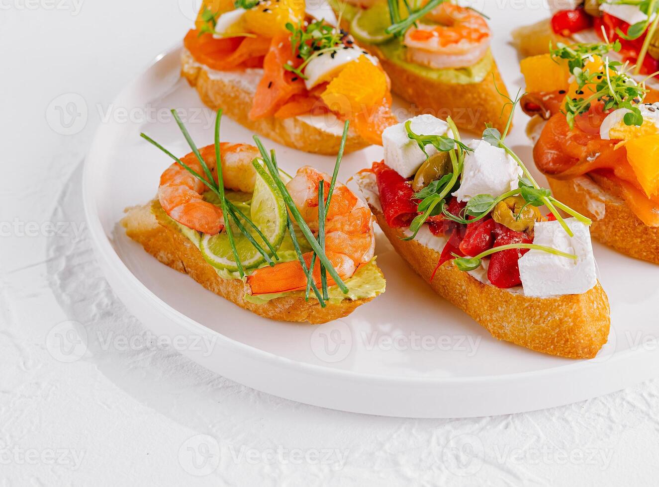 Elegant platter of assorted bruschetta with fresh toppings on a white background photo