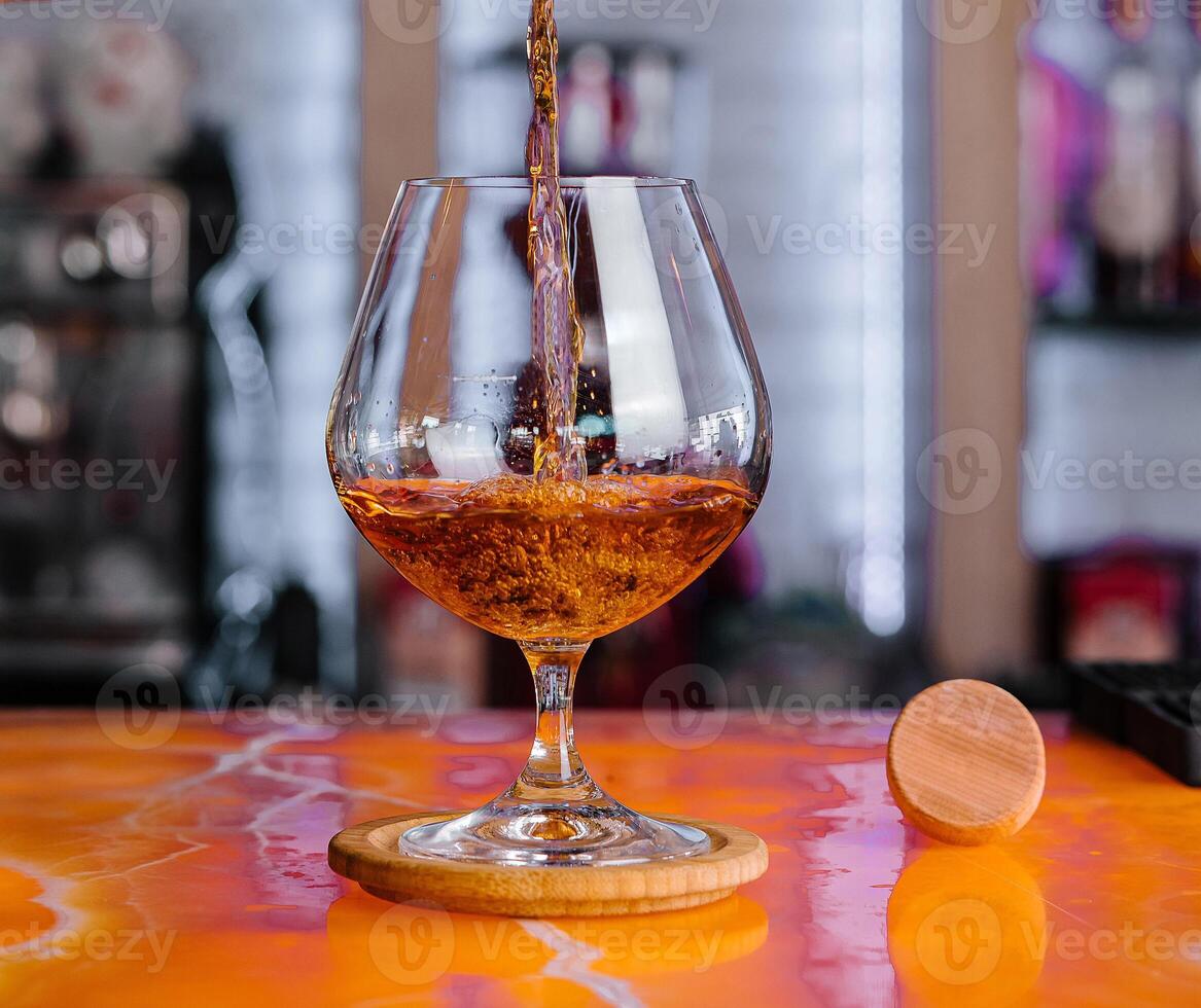 Pouring whiskey into glass at bar photo