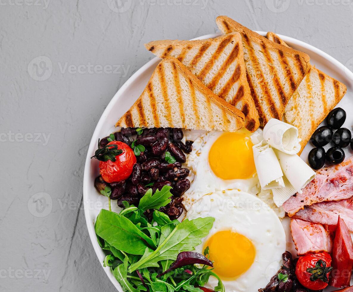 Full breakfast plate with eggs, bacon, and toast photo