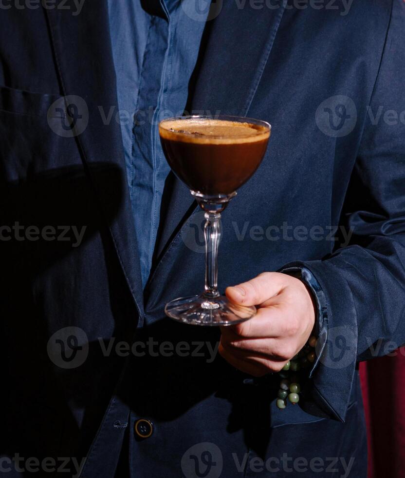 Man in suit holding espresso martini cocktail photo