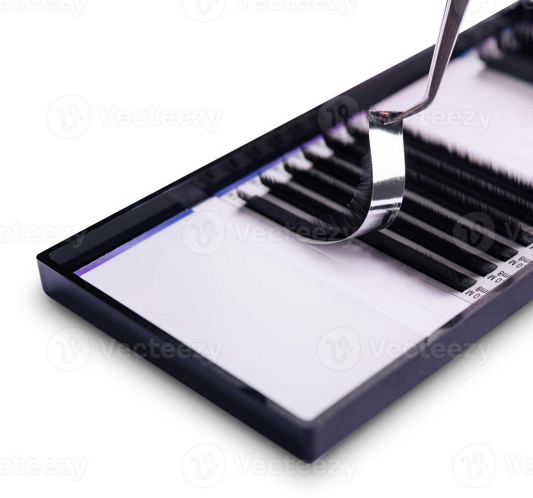 Close-up image of tweezers holding an eyelash extension above a tray photo