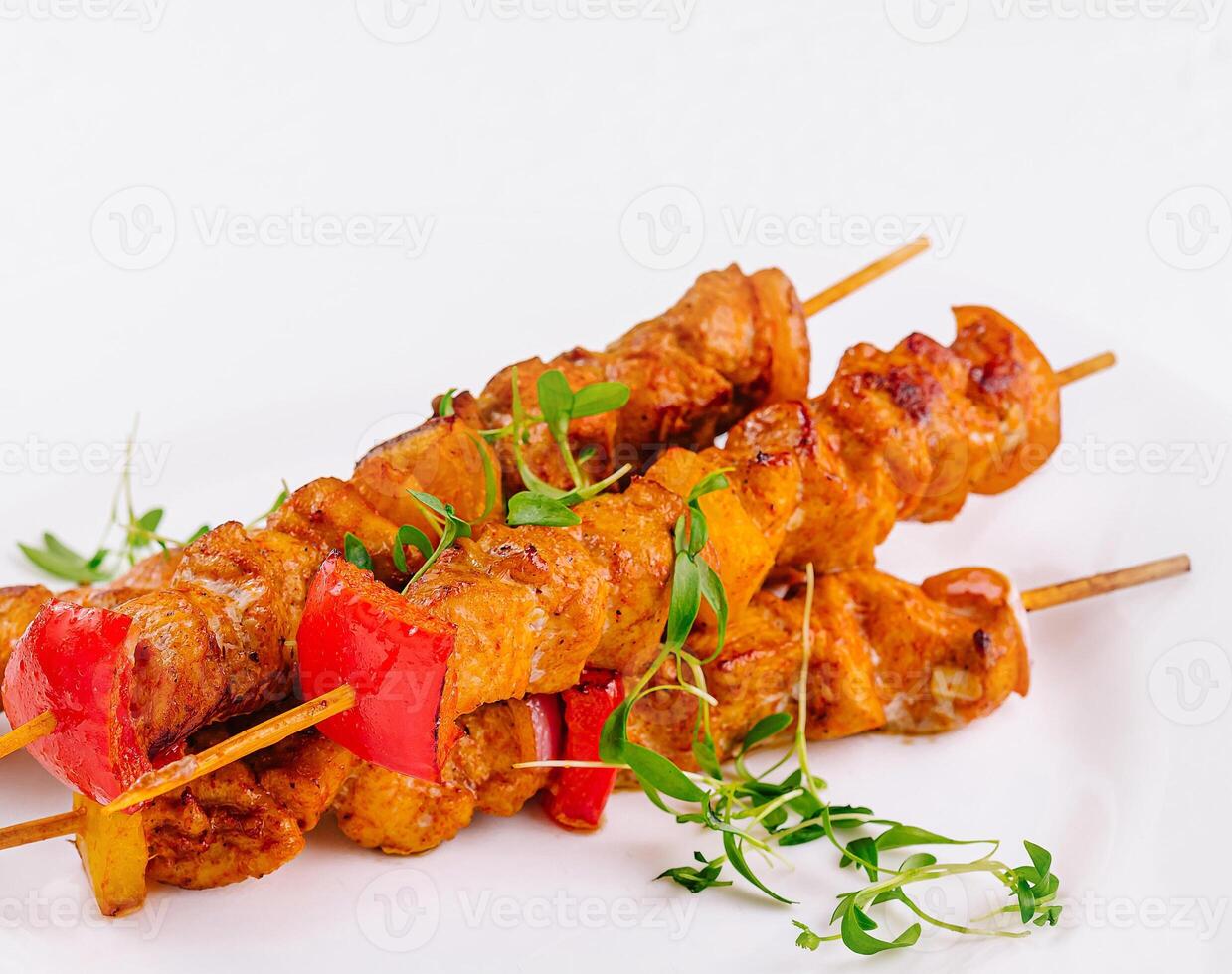 Juicy grilled chicken skewers on white plate photo