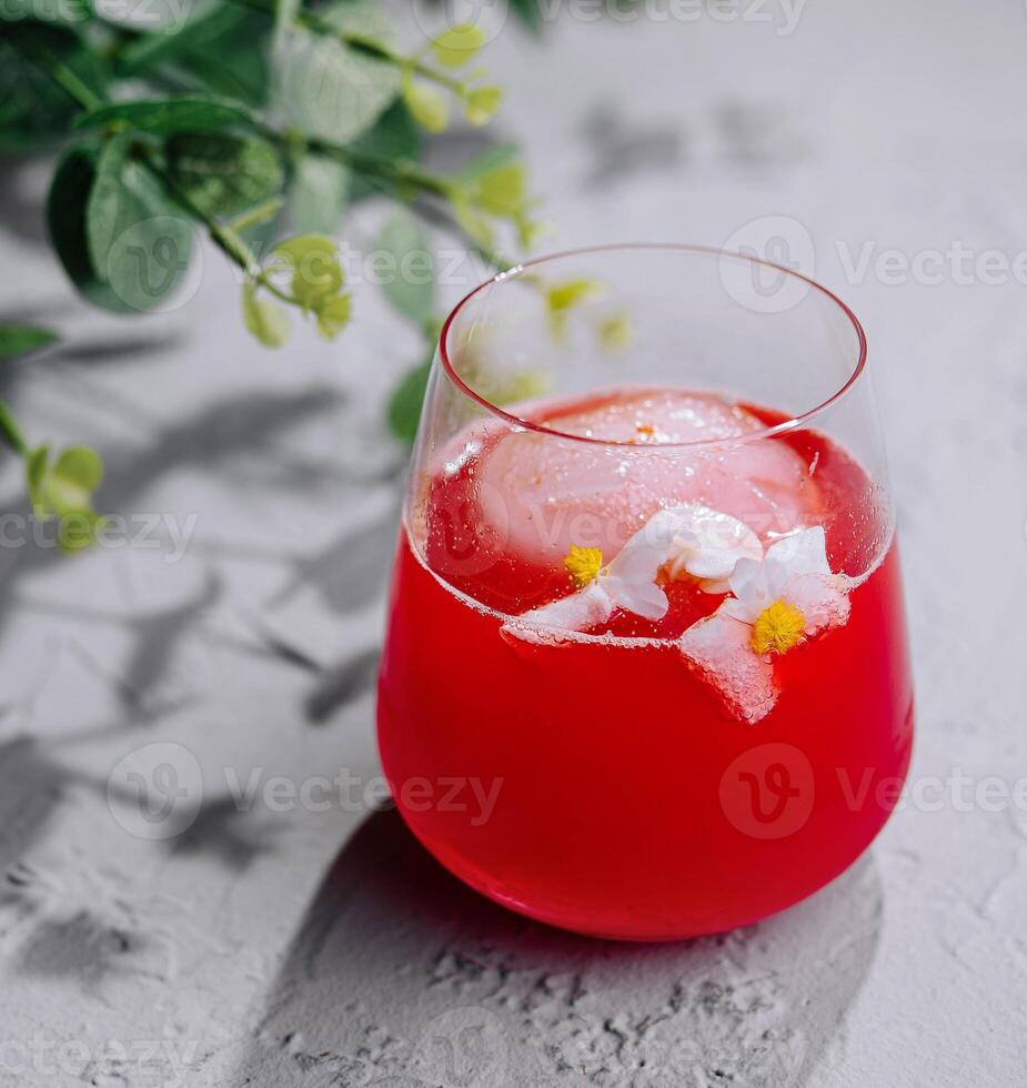 Refreshing red cocktail with flower garnish photo