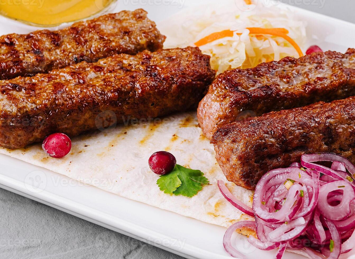Grilled kebabs platter with sauces and salad photo