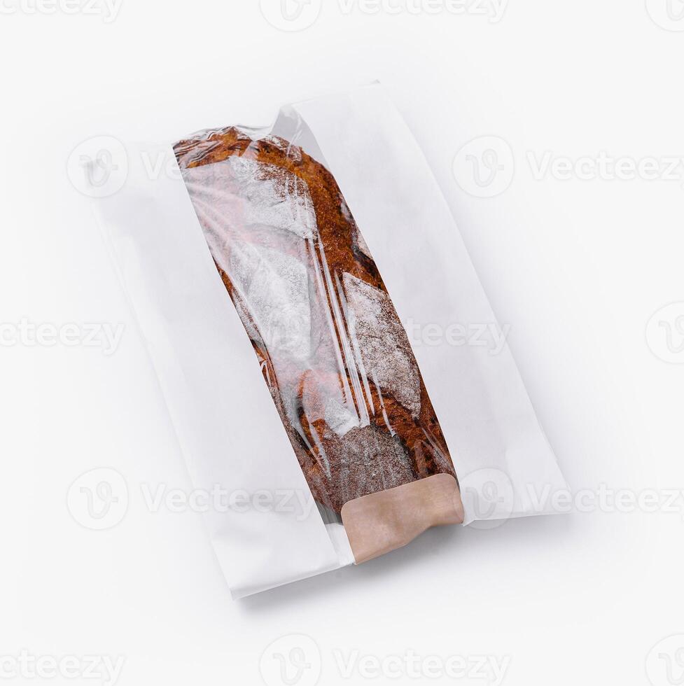 Fresh baguette in paper bag isolated on white photo