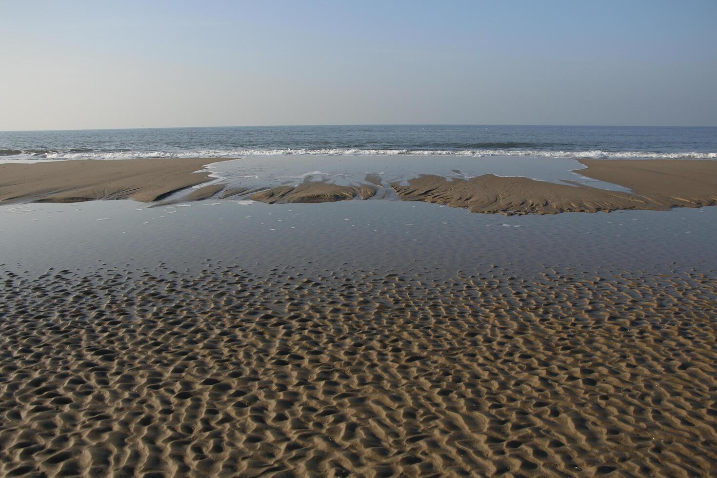 low tide with pools at the beach, little frost,winter in the netherlands photo