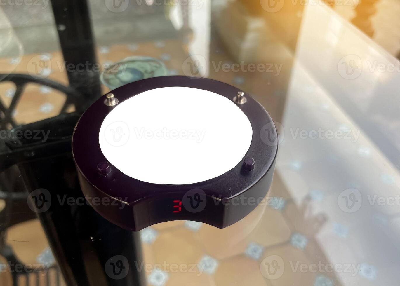 queue pager on restaurant glass table. It is a wireless technology device used to give an audible signal to notify customers so that they can pick up the ordered products by themselves. photo