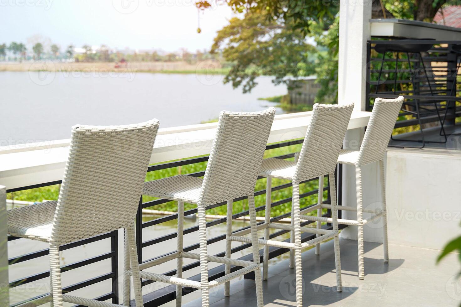 White faux rattan bar chair set. It's furniture that helps add a decorative style to the seating area outside the coffee shop by the lake to make it comfortable. beauty and distinctiveness photo