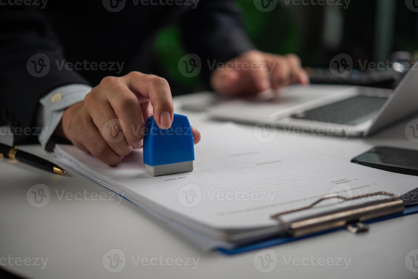 Hand stamping approval on an official document, workflow concept. photo