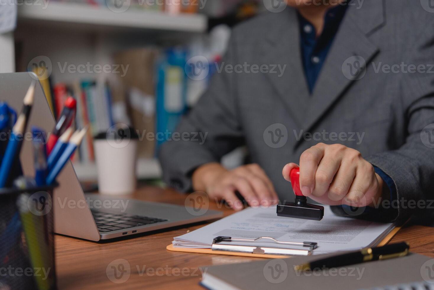 A professional applies an official seal to company documents, signifying authentication and approval. photo