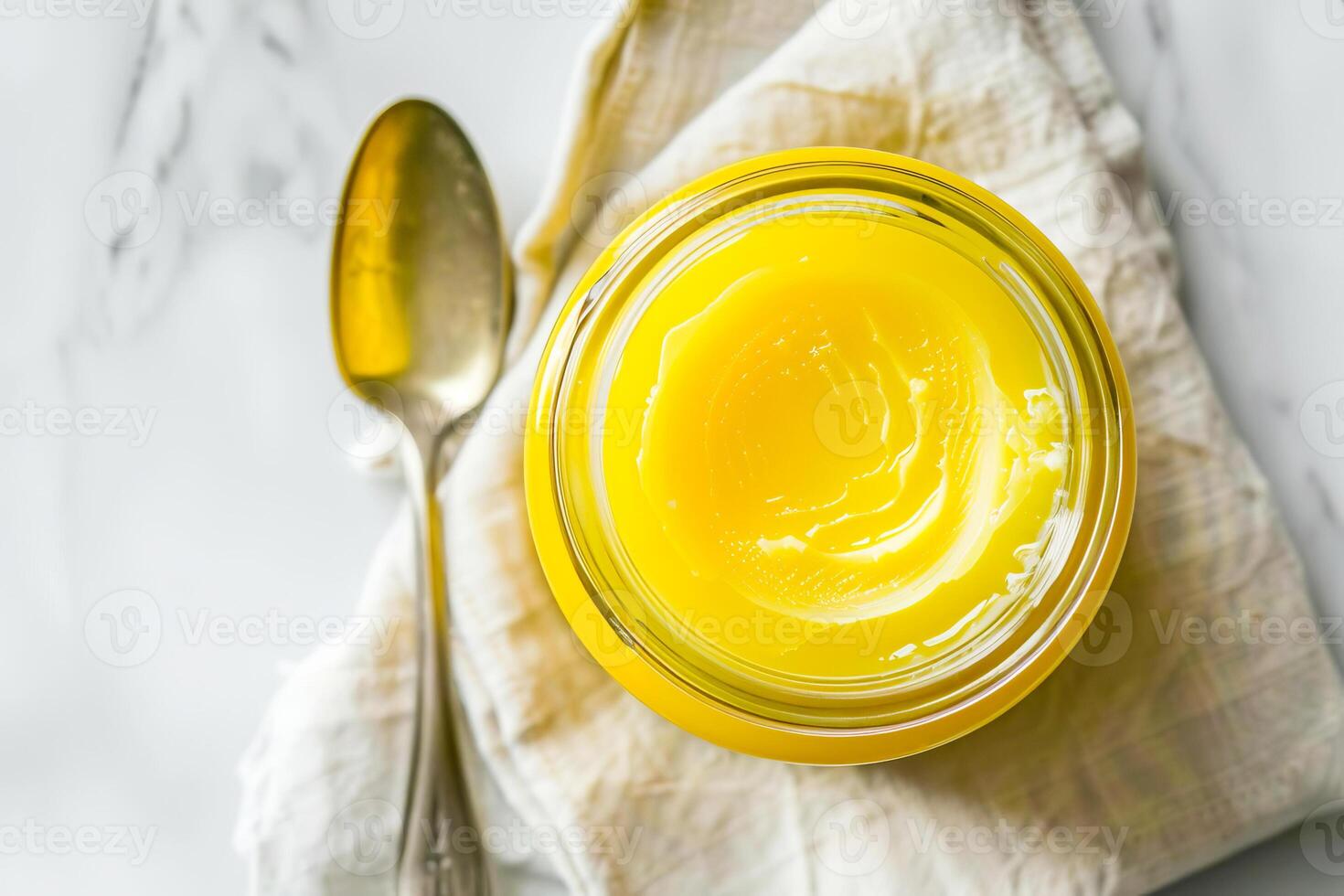 Top view, jar of ghee on a linen napkin with a spoon. photo