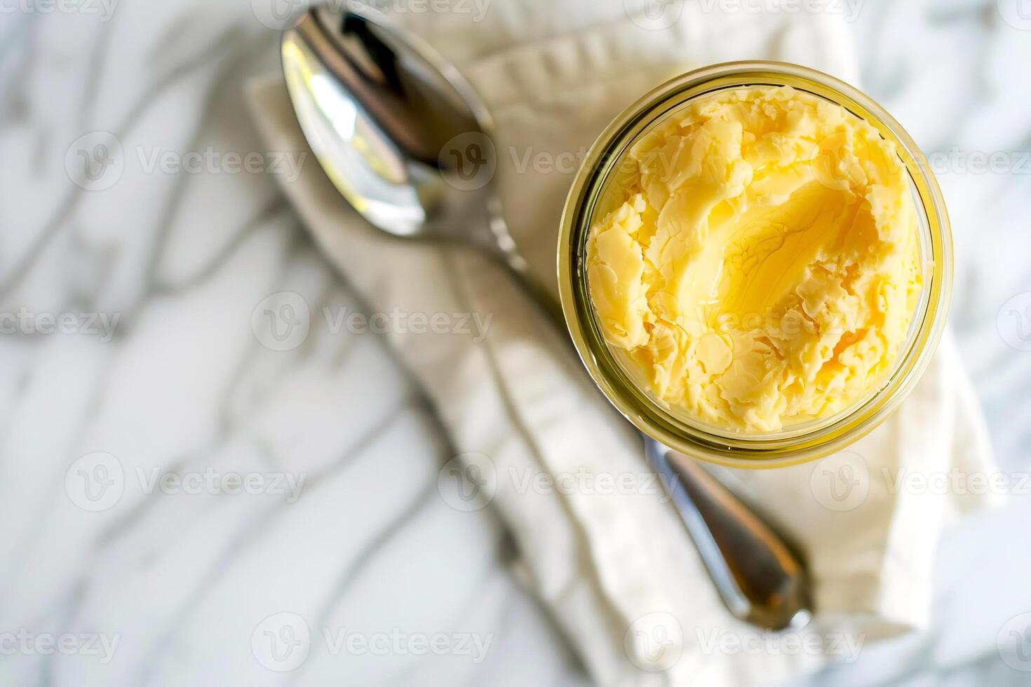 Top view, jar of ghee on a linen napkin with a spoon. photo
