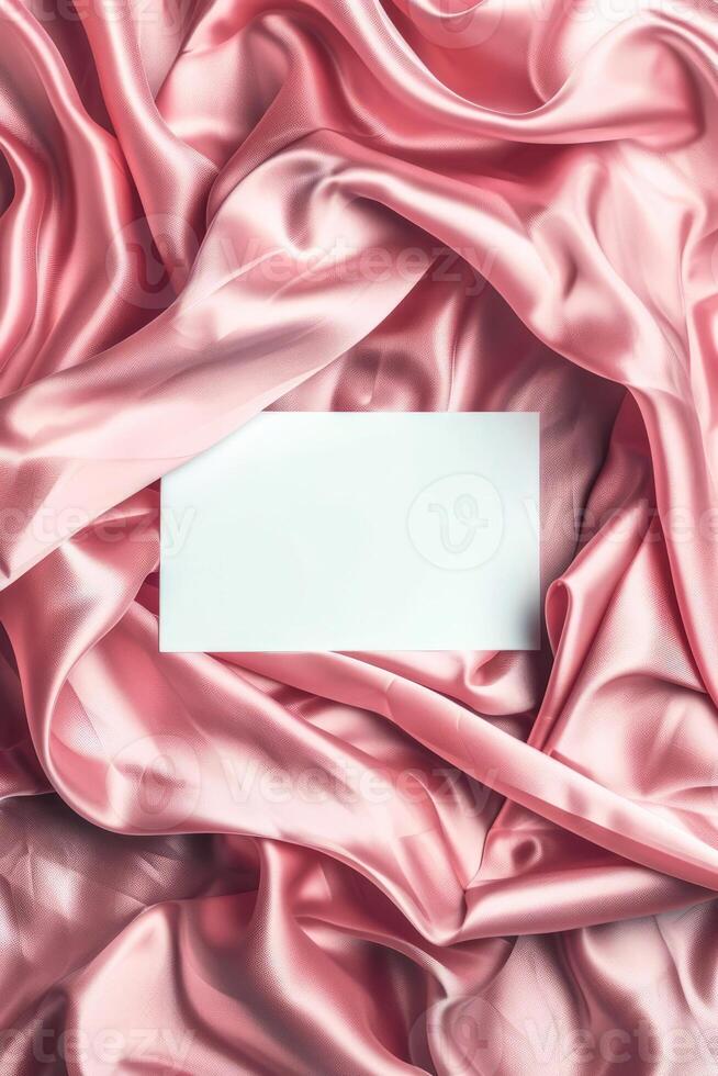 Minimalist aesthetic mockup of white blank A5 envelope on pink silk fabric. photo