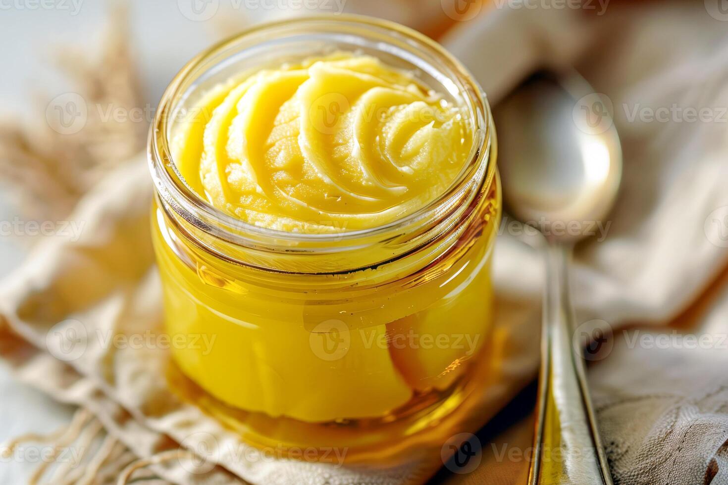 Top view, jar of ghee on a linen napkin with a spoon. photo