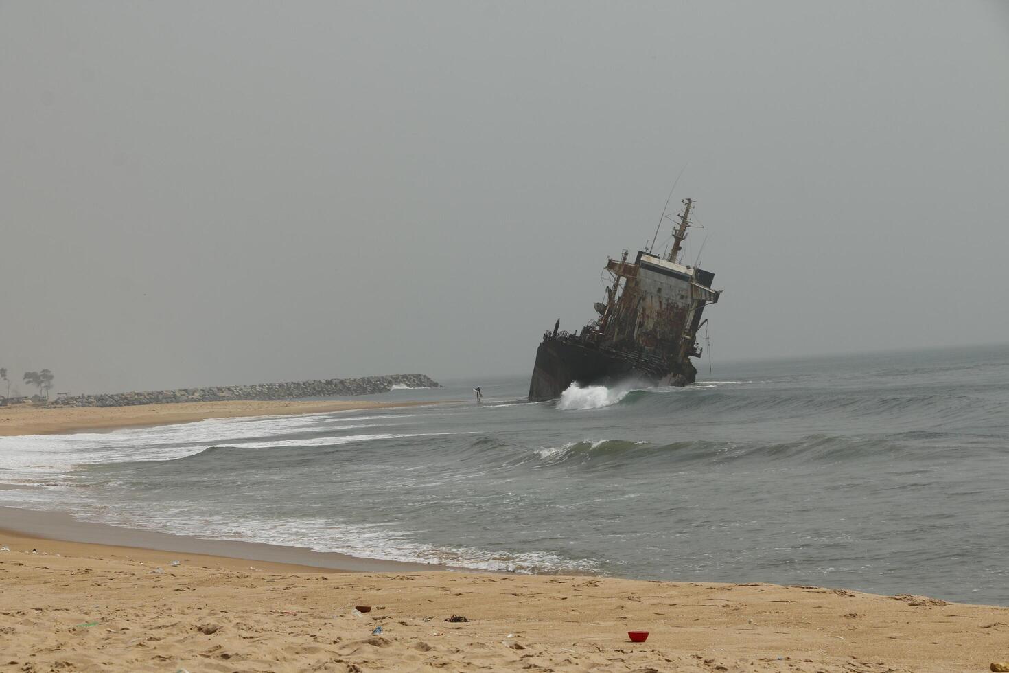 shipwreck against which the waves crash, cotonou, benin photo