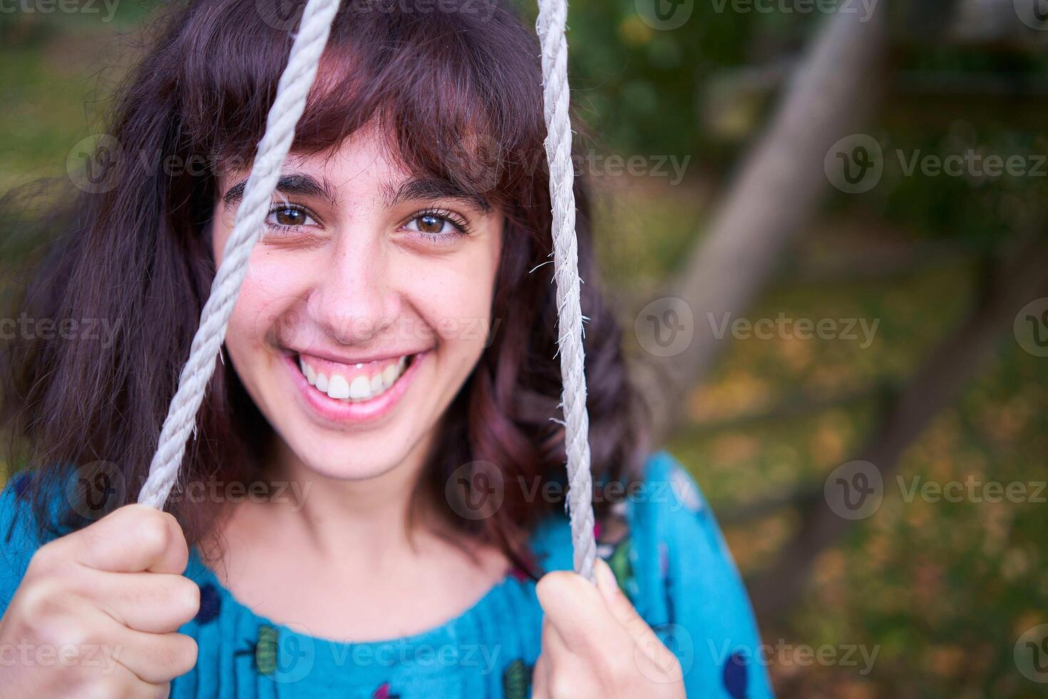 girl in a dress with balloons on a swing in an autumn garden photo