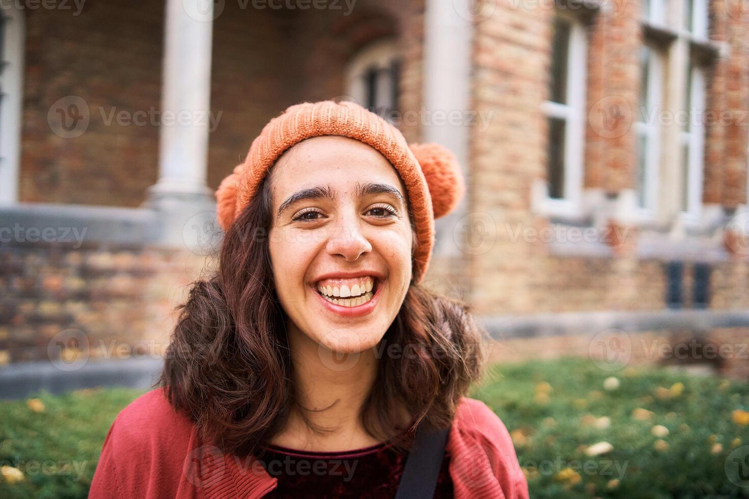 a girl in a hat with pom-poms walks the streets of Bruges on an autumn day photo