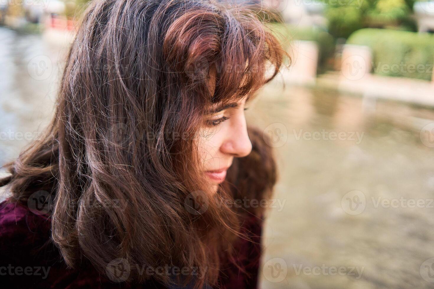 a girl in a red corduroy dress with an open back walks through the streets of Bruges on an autumn day photo