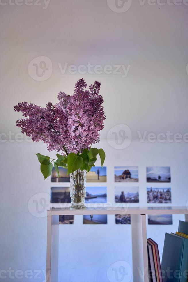 a bouquet of lilacs in a crystal vase in the interior photo