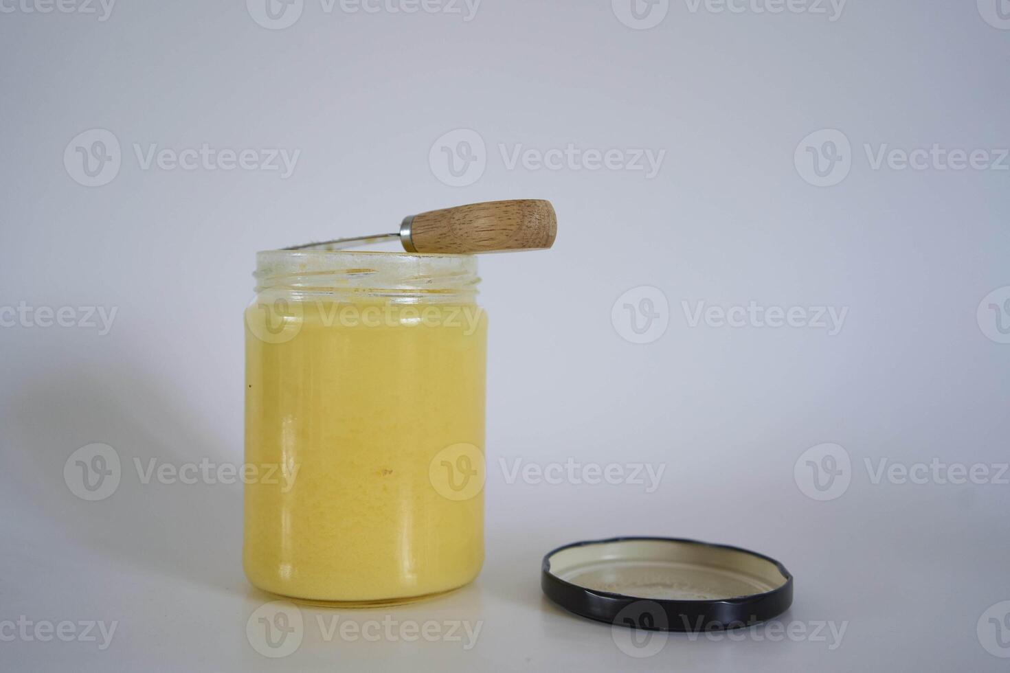 butter ghee in a transparent jar with homemade bread on a white background photo