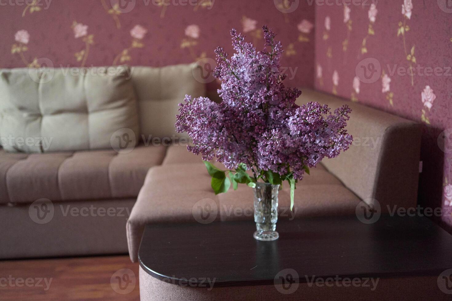a bouquet of lilacs in a crystal vase in the interior photo