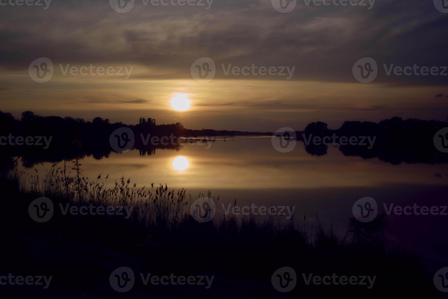 a man in a kayak in the middle of a lake at sunset photo