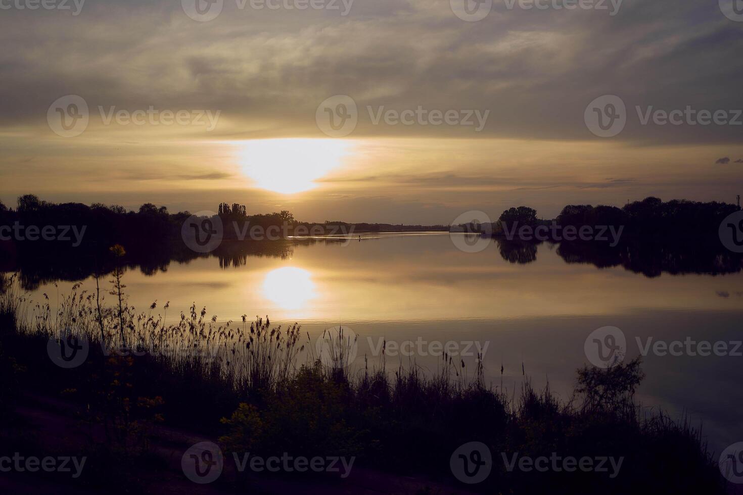 a man in a kayak in the middle of a lake at sunset photo