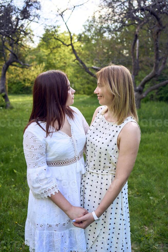a mother and her teenage daughter are hugging and playing in the garden photo