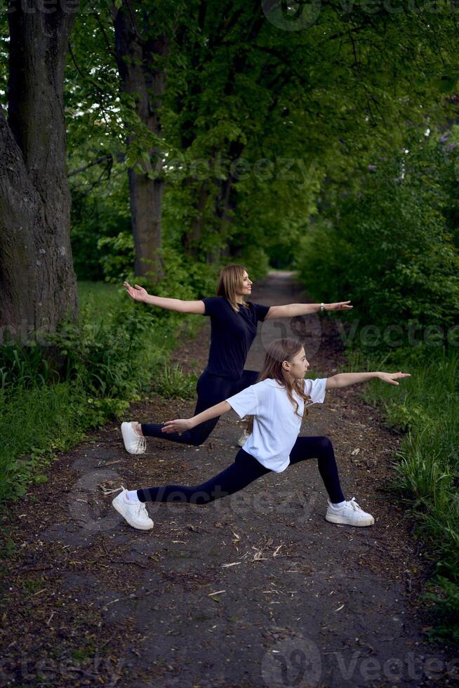 mother and daughter do sports and play in the park photo