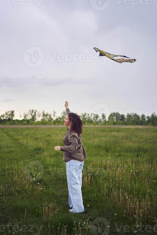 two little sisters and mother run and launch a kite in a field photo