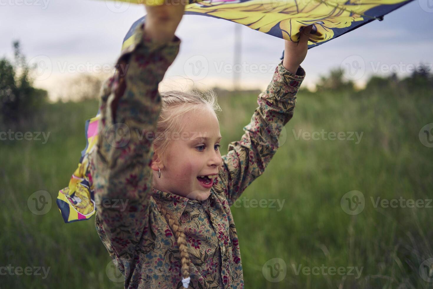 two little sisters repair and fly a kite in a field photo