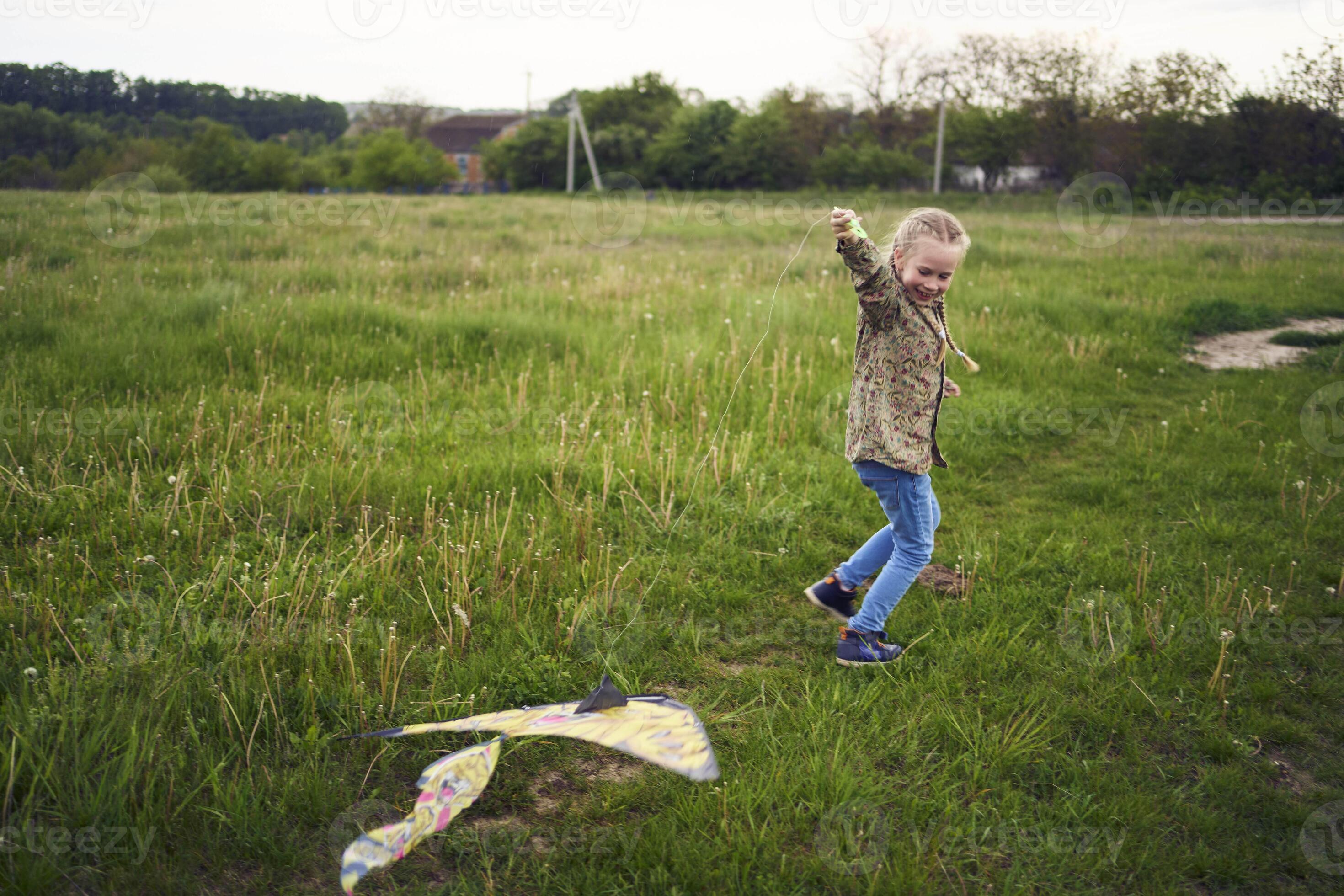 8yearold girl flies a kite in a field in a thunderstorm 45641930