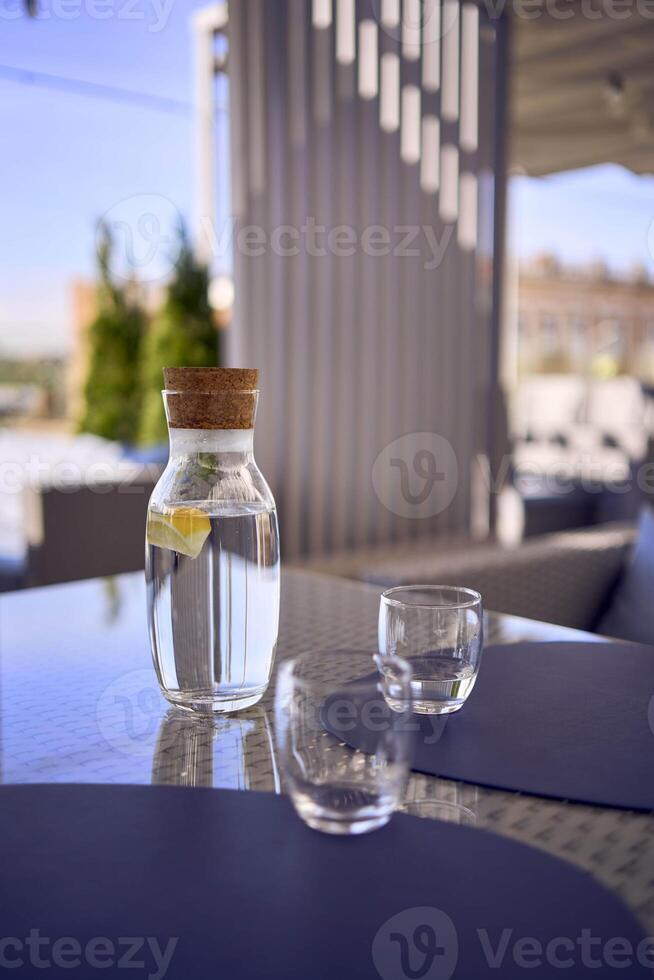 plus size woman in peach fuzz dress chooses a dish in a restaurant via QR code in smartphone, water with lemon and glasses in front of her photo